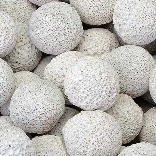 A close-up pile of porous white spherical balls made for aquarium biological filters